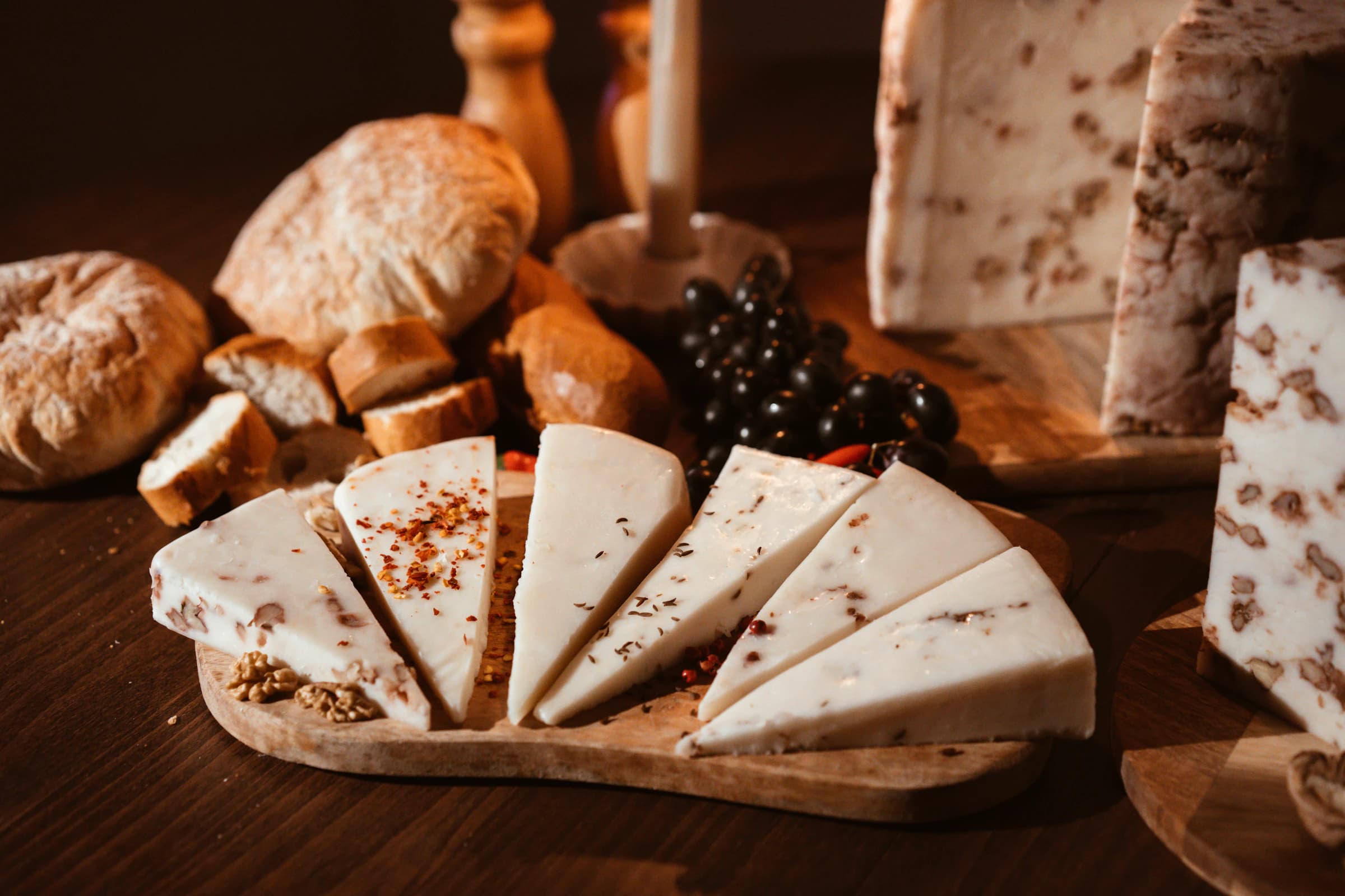 Großer Holztisch mit Brettljause, mehrere Generationen sitzen drumherum.